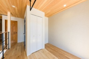 バルコニー前室には収納と室内干しスペースがあります。床の木製ルーバーは玄関土間空間を明るくするためのアイデアです。