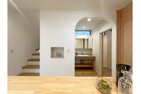 キッチンから望む洗面台前のアールの垂れ壁。オシャレだと好評です